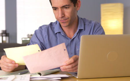 man sitting at his desk going through tax returns